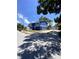 Charming two-story blue home featuring a well-manicured front yard and long driveway leading to a detached garage at 1947 Los Lomas Dr, Clearwater, FL 33763