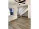 Bright living room with new floors, staircase, a ceiling fan and natural light through the window at 1947 Los Lomas Dr, Clearwater, FL 33763