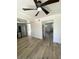 Open-concept living room featuring wood floors, white walls, and stainless steel appliances at 1947 Los Lomas Dr, Clearwater, FL 33763