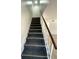 Staircase with gray carpet and a handrail leading to the upstairs bedrooms and living areas at 1947 Los Lomas Dr, Clearwater, FL 33763