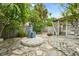Charming backyard featuring a stone patio and a tranquil water fountain feature at 2015 Bayshore Gardens Pkwy, Bradenton, FL 34207