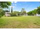 Expansive backyard with lush lawn, mature trees, and a screened-in lanai offering a serene outdoor living space at 2015 Bayshore Gardens Pkwy, Bradenton, FL 34207