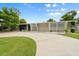 Unique modern home with a curved driveway, decorative white slats, and minimalist landscaping for curb appeal at 2015 Bayshore Gardens Pkwy, Bradenton, FL 34207