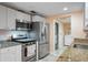 Modern kitchen boasts stainless steel appliances, granite countertops, and white cabinetry at 2015 Bayshore Gardens Pkwy, Bradenton, FL 34207