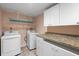 Functional laundry room with washer, dryer, counter space, and ample cabinet storage at 2015 Bayshore Gardens Pkwy, Bradenton, FL 34207