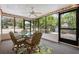 Cozy sunroom with glass table, wicker chairs, and a view of the landscaped backyard at 2015 Bayshore Gardens Pkwy, Bradenton, FL 34207