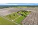 Aerial view of a house on a large lot with white perimeter fence and tree coverage, and surrounding farmland at 2350 Virgil Hall Rd, Lithia, FL 33547
