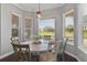 Bright breakfast nook with large windows overlooking a green pasture, hardwood floors, and a modern pendant light at 2350 Virgil Hall Rd, Lithia, FL 33547
