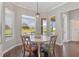 Bright breakfast nook with large windows overlooking a green pasture, hardwood floors, and a modern pendant light at 2350 Virgil Hall Rd, Lithia, FL 33547