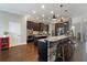 Kitchen featuring a stone-clad island with bar seating, dark cabinets, and stainless steel appliances at 2350 Virgil Hall Rd, Lithia, FL 33547