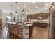 Spacious kitchen with a large stone-accented island, stainless steel appliances, and dark wood cabinets at 2350 Virgil Hall Rd, Lithia, FL 33547