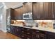 Gourmet kitchen boasts granite counters, stainless steel appliances, and custom dark wood cabinetry at 2350 Virgil Hall Rd, Lithia, FL 33547