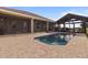 Backyard with a pool, brick patio, screened lanai, and outdoor pavilion, perfect for relaxing and entertaining at 2350 Virgil Hall Rd, Lithia, FL 33547