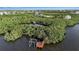 Aerial view of dock and boathouse, surrounded by mangrove trees at 2400 Miguel Bay Dr, Terra Ceia, FL 34250