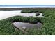 Aerial view of serene pond with dock, gazebo, and mangroves at 2400 Miguel Bay Dr, Terra Ceia, FL 34250