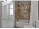 Renovated bathroom featuring a tub shower with marble tile and modern fixtures at 2400 Miguel Bay Dr, Terra Ceia, FL 34250