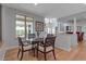 Dining area featuring wood floors, a glass table, decorative chairs, and serene views at 2400 Miguel Bay Dr, Terra Ceia, FL 34250