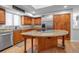 Well-lit kitchen with a large island, stainless steel refrigerator, and abundant cabinet space at 2400 Miguel Bay Dr, Terra Ceia, FL 34250