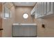 Well-lit laundry room with ample cabinet space, grey lower cabinets, and a round window at 2400 Miguel Bay Dr, Terra Ceia, FL 34250
