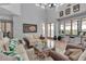 A lovely living area with a decorative chandelier, large windows, and a unique glass coffee table at 2400 Miguel Bay Dr, Terra Ceia, FL 34250