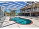 Rear exterior view of a house showing a backyard oasis with pool and hot tub inside a screened enclosure at 2400 Miguel Bay Dr, Terra Ceia, FL 34250