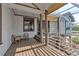 Inviting covered porch with wicker furniture, offering shade and access to the home's entrance at 2400 Miguel Bay Dr, Terra Ceia, FL 34250