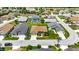 An aerial view shows a charming neighborhood with manicured lawns, lush landscaping, and community pool at 24512 Bramhope Ct, Punta Gorda, FL 33980
