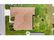 A real estate aerial showcases a home with a well-manicured lawn, lush landscaping, and a brown roof at 24512 Bramhope Ct, Punta Gorda, FL 33980
