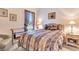 Inviting bedroom featuring a comfortable bed, side table, and large window with curtains at 24512 Bramhope Ct, Punta Gorda, FL 33980