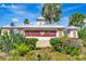 A community sign for Kings Gate is surrounded by lush landscaping and mature palm trees at 24512 Bramhope Ct, Punta Gorda, FL 33980