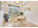 Charming dining area features tile flooring, a ceiling fan, and a large window with shutter-style blinds at 24512 Bramhope Ct, Punta Gorda, FL 33980