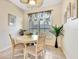 Bright dining area featuring tiled floors, a round table with four chairs, and large window with shutter blinds at 24512 Bramhope Ct, Punta Gorda, FL 33980