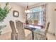 Bright dining room with glass table, upholstered chairs, large window, and decorative accents at 24512 Bramhope Ct, Punta Gorda, FL 33980