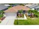 Aerial shot of the home showcasing its manicured lawn, charming landscaping, and a two-car garage at 24512 Bramhope Ct, Punta Gorda, FL 33980