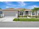 Charming single-story home featuring a well-manicured lawn, lush landscaping, and a two-car garage at 24512 Bramhope Ct, Punta Gorda, FL 33980
