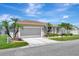 Charming home exterior with a two-car garage, lush landscaping, and a well-manicured lawn at 24512 Bramhope Ct, Punta Gorda, FL 33980