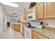Functional kitchen featuring wood cabinets, granite countertops, and white appliances at 24512 Bramhope Ct, Punta Gorda, FL 33980
