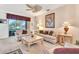 Cozy living room features plush sofas, a ceiling fan, and large windows offering natural light and views at 24512 Bramhope Ct, Punta Gorda, FL 33980