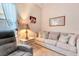 Comfortable living room featuring a plush sofa, accent chair, and a side table with a charming lamp at 24512 Bramhope Ct, Punta Gorda, FL 33980