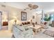 Spacious living room showcasing comfortable seating, neutral carpeting, and bright, airy atmosphere at 24512 Bramhope Ct, Punta Gorda, FL 33980
