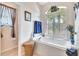 Inviting bathroom with soaking tub, shuttered windows, and decorative accents at 24512 Bramhope Ct, Punta Gorda, FL 33980
