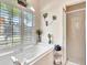 Bright bathroom with a soaking tub, shower, and shuttered window at 24512 Bramhope Ct, Punta Gorda, FL 33980