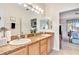 Bathroom featuring double sinks, granite countertops, wood cabinets, and a large mirror at 24512 Bramhope Ct, Punta Gorda, FL 33980
