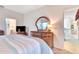 Main bedroom featuring a wooden dresser and a door leading to an adjacent area at 24512 Bramhope Ct, Punta Gorda, FL 33980