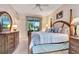 Well-lit main bedroom featuring a four-poster bed, dresser, and bedside table at 24512 Bramhope Ct, Punta Gorda, FL 33980