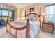 Comfortable main bedroom with a four-poster bed, bedside table, and sliding glass door at 24512 Bramhope Ct, Punta Gorda, FL 33980