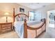 Relaxing main bedroom with a four-poster bed, bedside table, and neutral decor at 24512 Bramhope Ct, Punta Gorda, FL 33980
