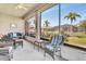 Relaxing screened patio featuring comfortable wicker furniture and a ceiling fan at 24512 Bramhope Ct, Punta Gorda, FL 33980