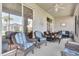 Outdoor patio featuring comfortable wicker furniture, ceiling fan, and view to tropical plants at 24512 Bramhope Ct, Punta Gorda, FL 33980