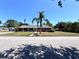 Charming one-story brick home featuring a well-manicured lawn and a mature palm tree in the front yard at 2720 12Th Ave W, Bradenton, FL 34205